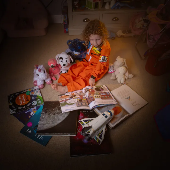Daughter sitting in a ring of books