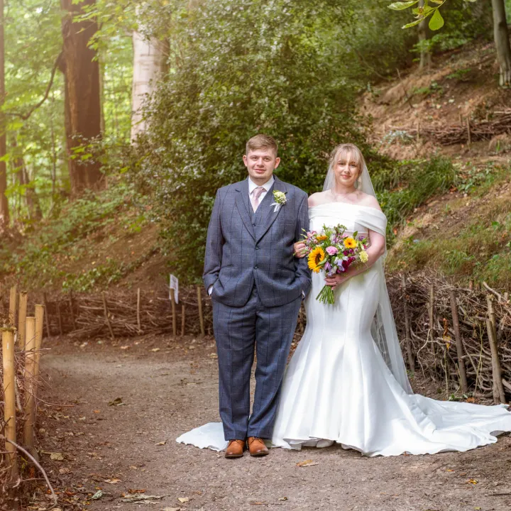 A couple on their wedding day standing in a forest