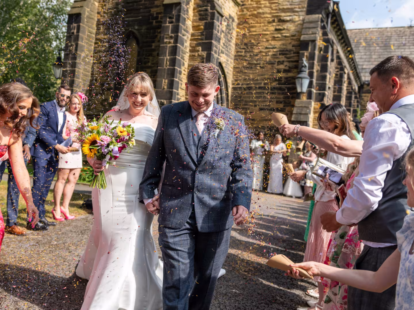 Just married couple walking through there guests being showered with confetti