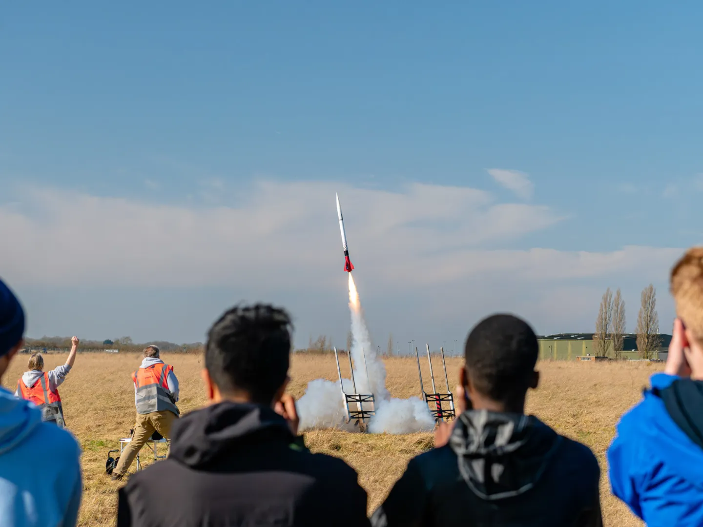 Four students watching a rocket launch