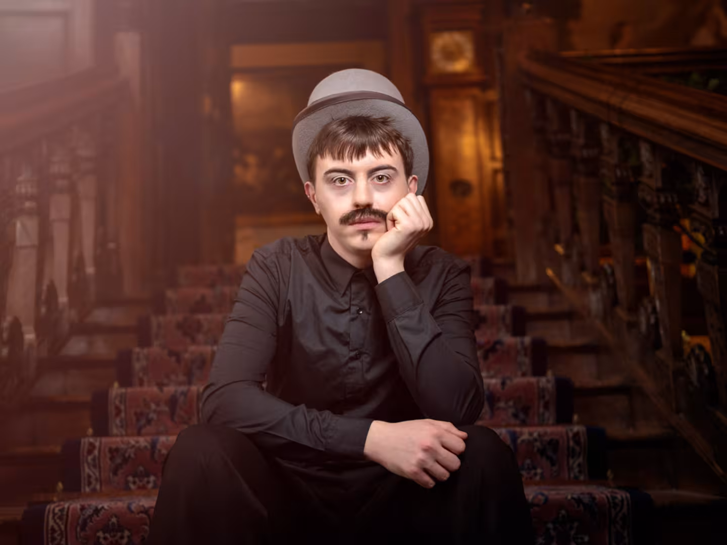Man sitting on stairs with a top hat