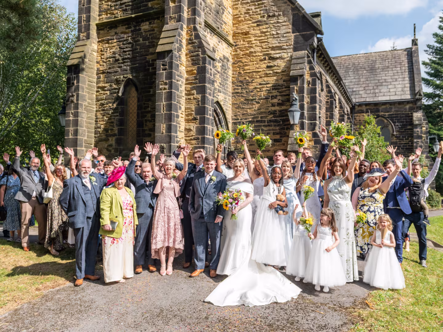 Large group shot of a wedding outside a church